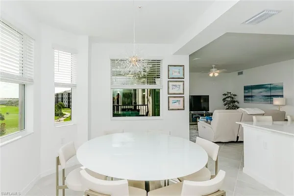 a living room with furniture a flat screen tv and a large window