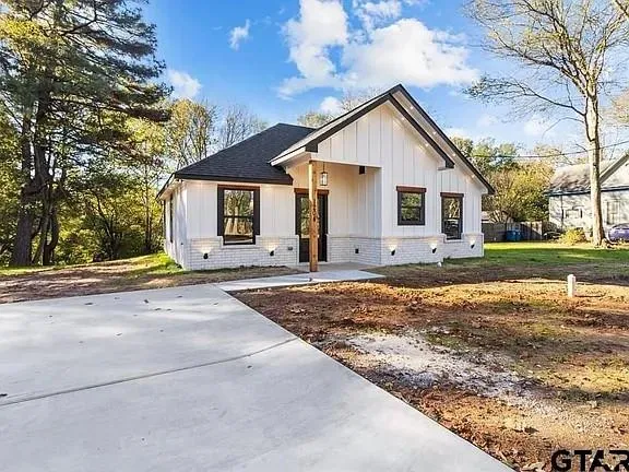 a front view of house with yard and trees around