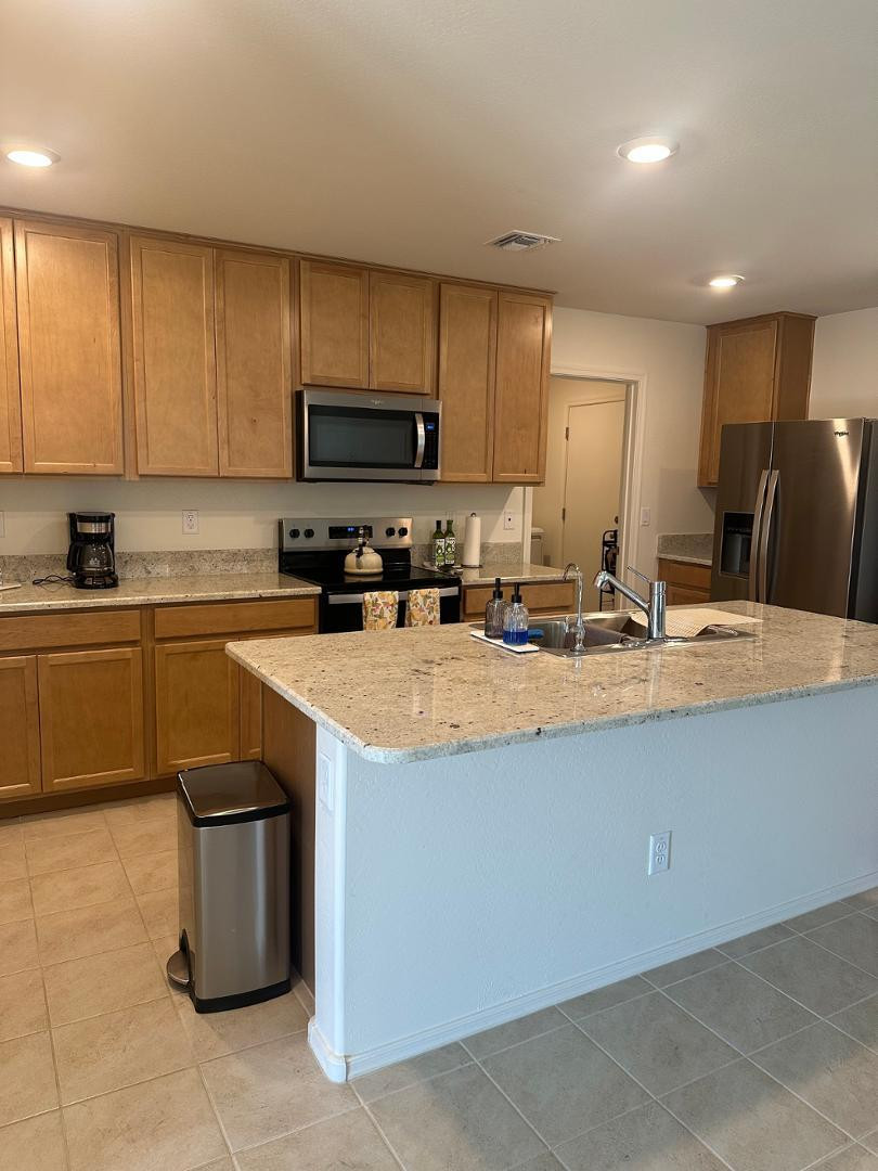 18255 West Pima Street Goodyear, AZ 85338 - Photo 2 of 12 a kitchen with stainless steel appliances granite countertop a sink a stove and a refrigerator