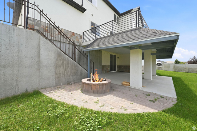1002 West Temple Rim Lane Payson, UT 84651 - Photo 55 of 68 Covered patio area with a concrete slab and a built-in fire pit on a paver base