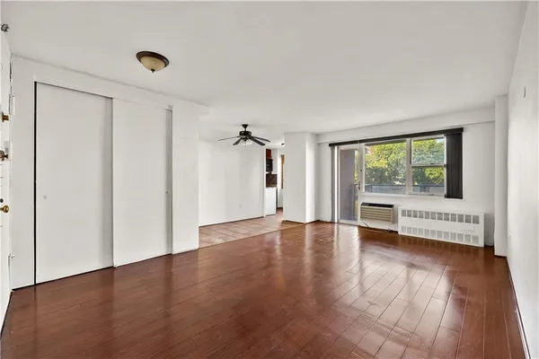a view of a big room with wooden floor and windows