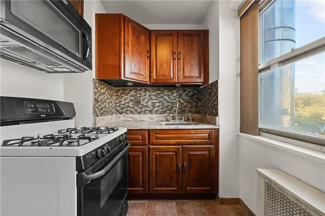 a kitchen with stainless steel appliances granite countertop a stove and a microwave