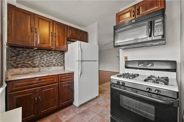 a kitchen with stainless steel appliances granite countertop a stove microwave refrigerator and cabinets