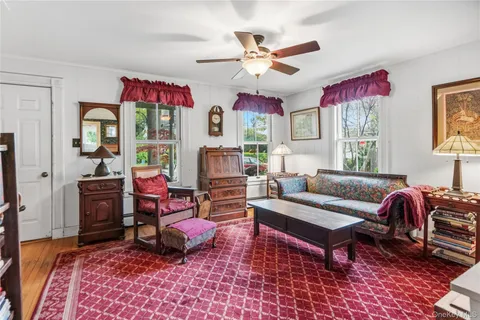 a living room with furniture a flat screen tv and a window