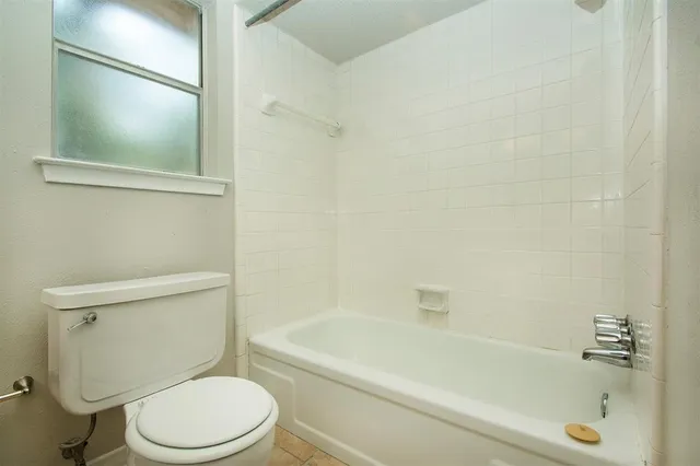 a white toilet sitting next to a bath tub