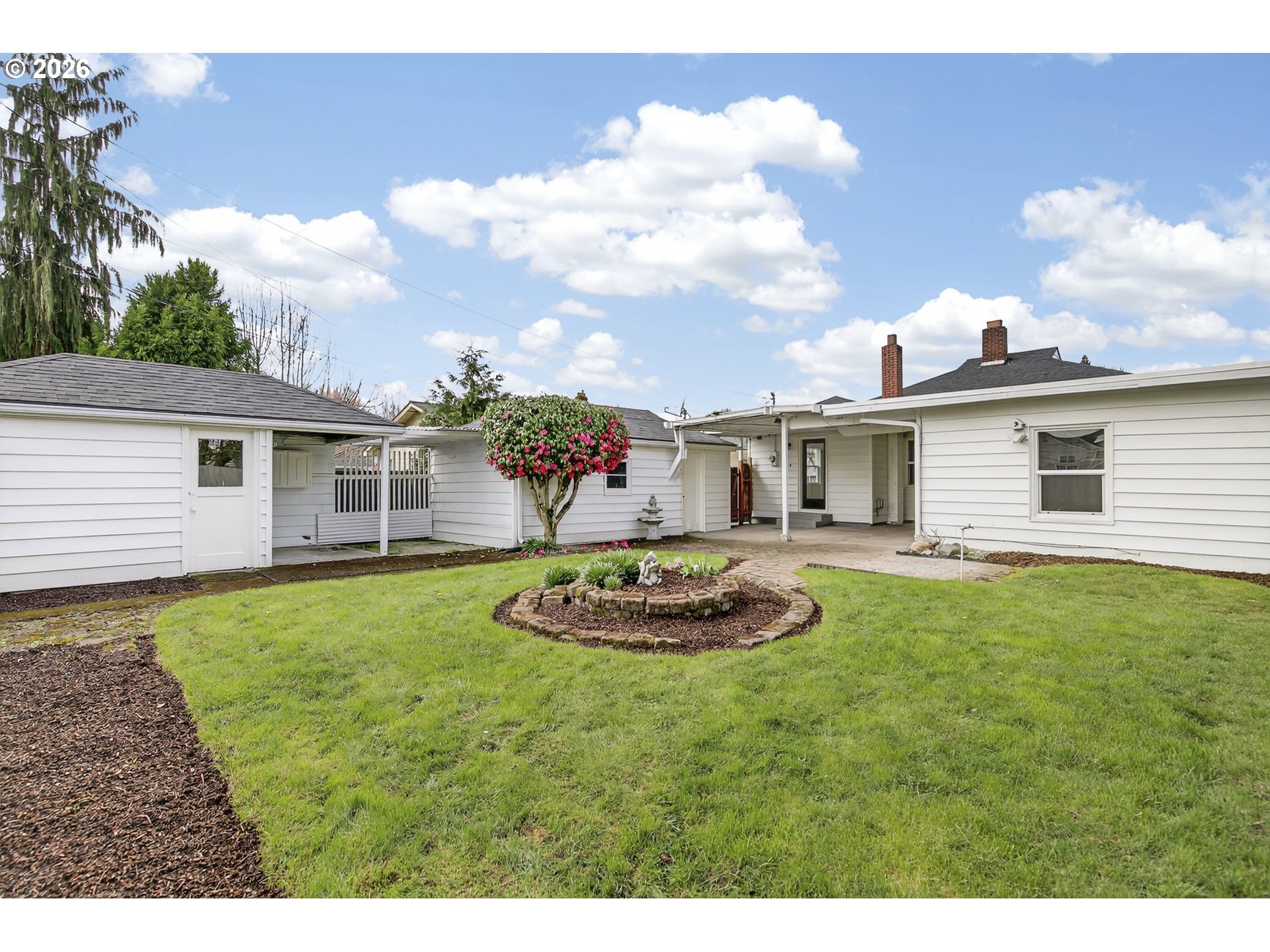 520 24th Avenue Longview, WA 98632 - Photo 35 of 37 a backyard of a house with table and chairs plants and large tree