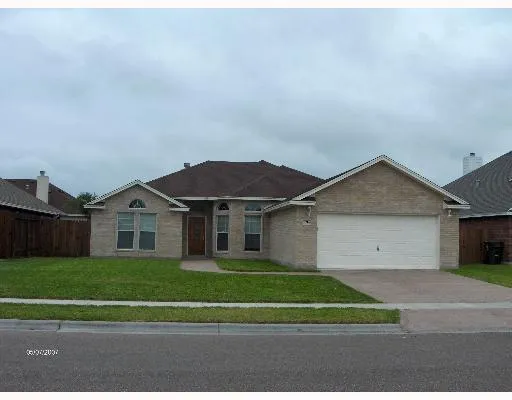 a front view of a house with a garden and yard