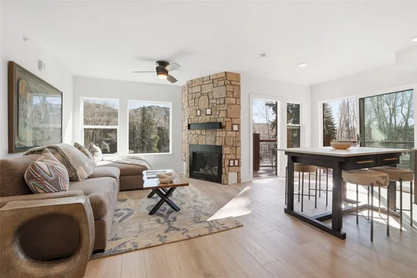 a living room with furniture a fireplace and a large window