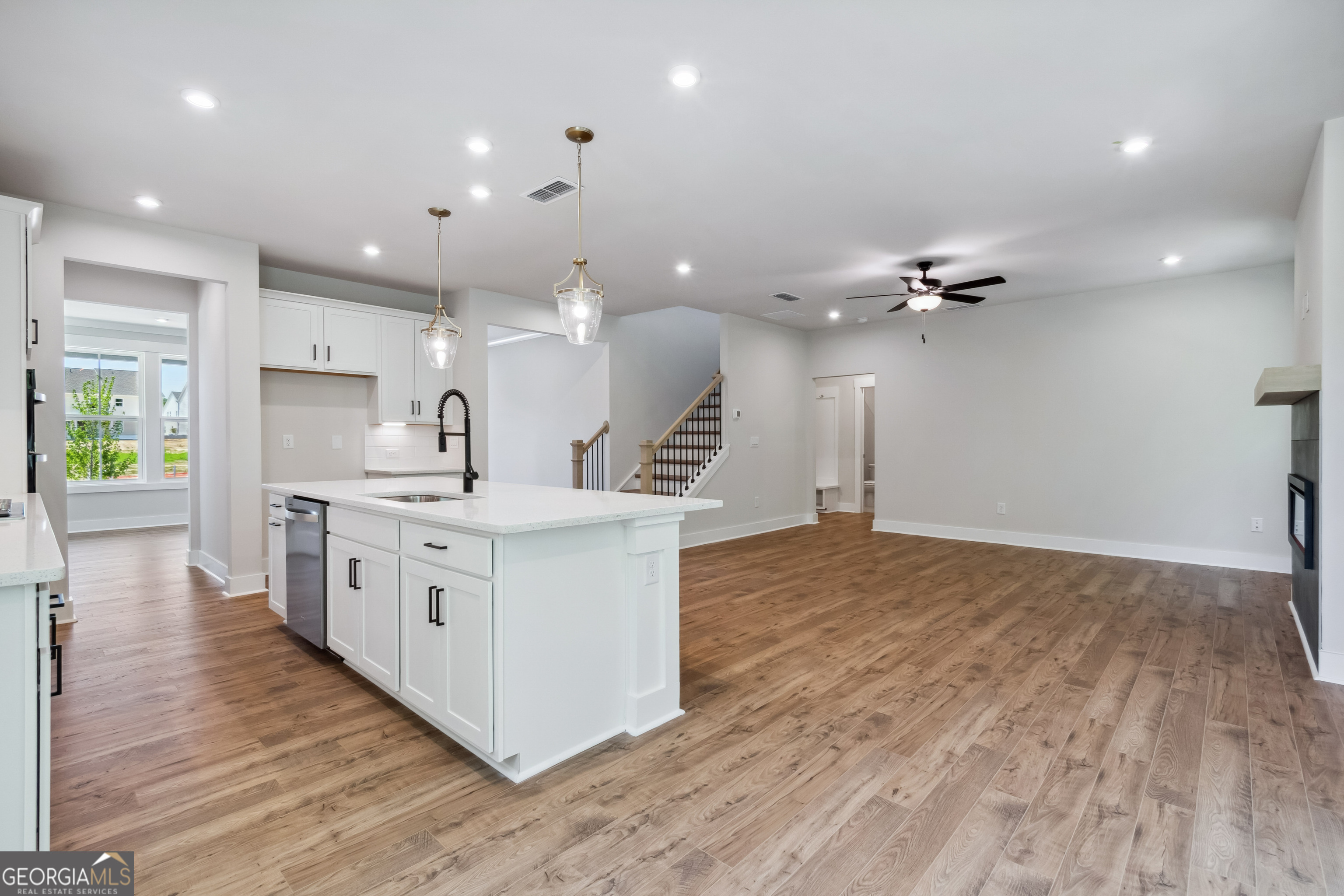 4002 Adler Circle, Unit 7 Buford, GA 30519 - Photo 12 of 38 a kitchen with stainless steel appliances kitchen island wooden floors cabinets and wooden floor