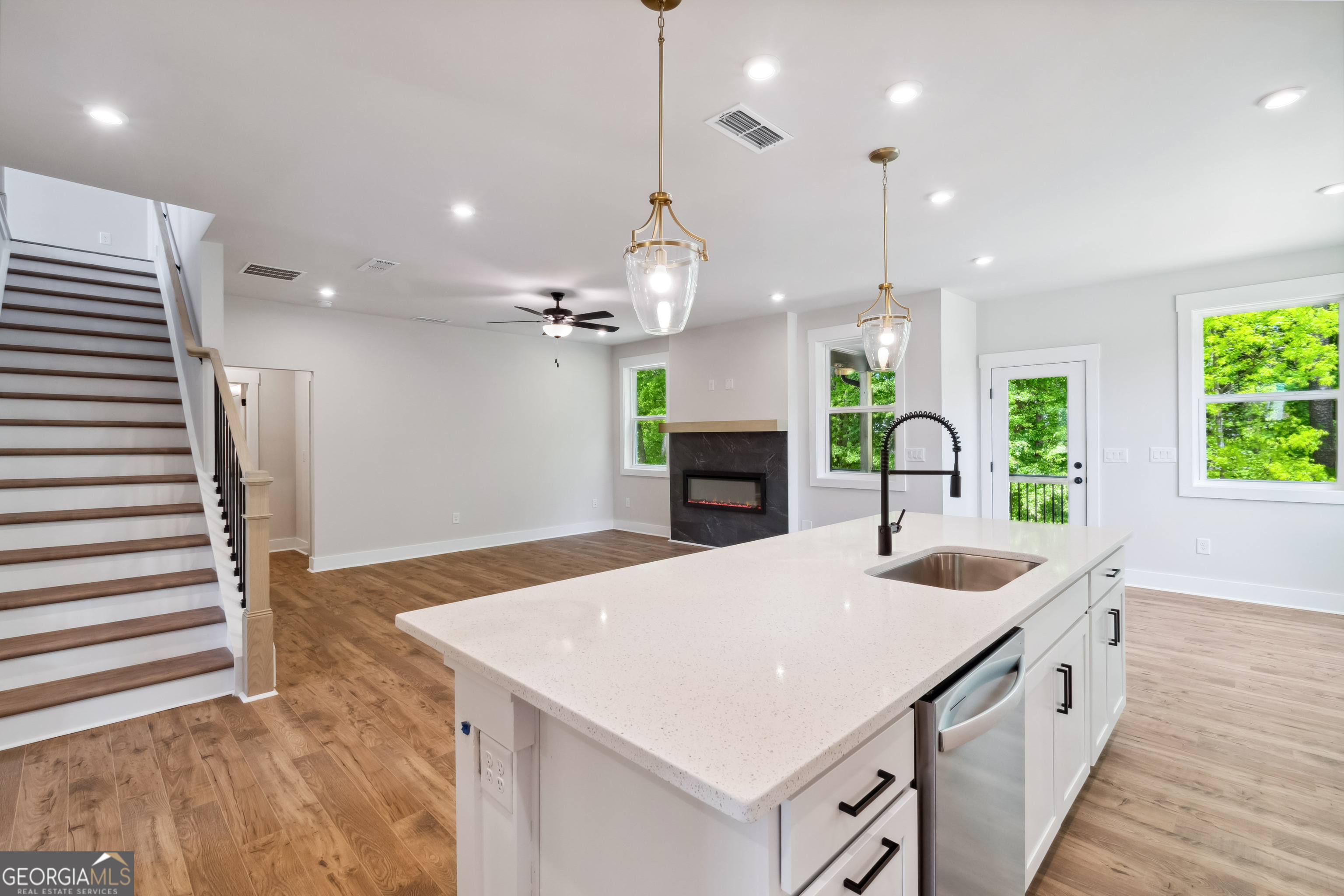 4002 Adler Circle, Unit 7 Buford, GA 30519 - Photo 13 of 38 a large white kitchen with a large island oven a stove a chimney a sink and dining table