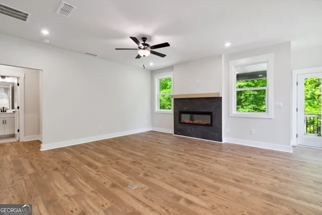 a view of empty room with fireplace and wooden floor