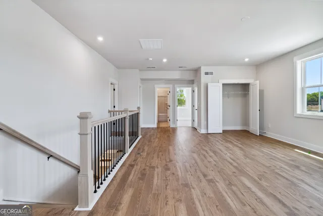 a view of a hallway with wooden floor and stairs