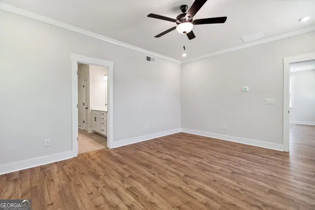 a view of a big room with wooden floor and a ceiling fan