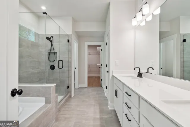 a spacious bathroom with a tub sink shower and mirror