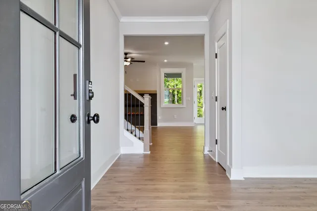 a view of a hallway with wooden floor and staircase