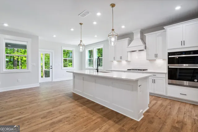 a large kitchen with granite countertop a large counter top appliances and cabinets