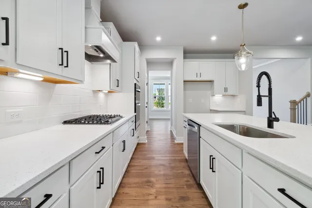 a kitchen with kitchen island white cabinets and sink