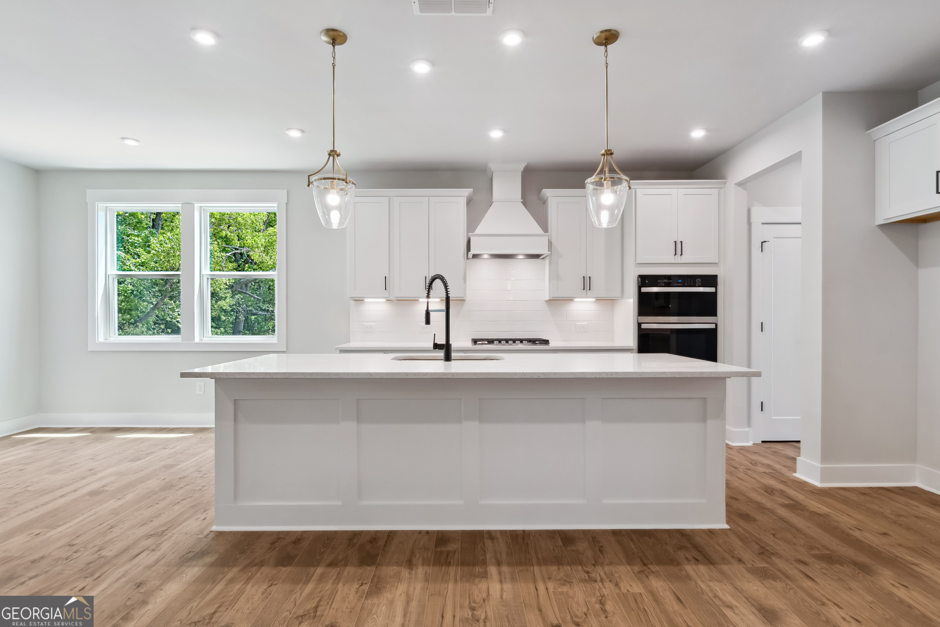 4002 Adler Circle, Unit 7 Buford, GA 30519 - Photo 10 of 38 a large kitchen with kitchen island a large counter space a sink appliances and a window