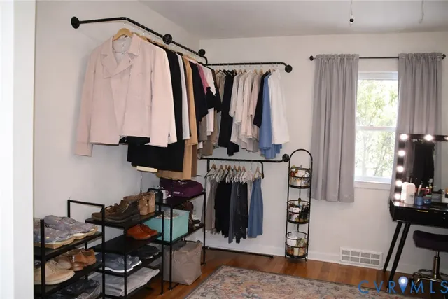 a view of walk in closet with clothes and shoes
