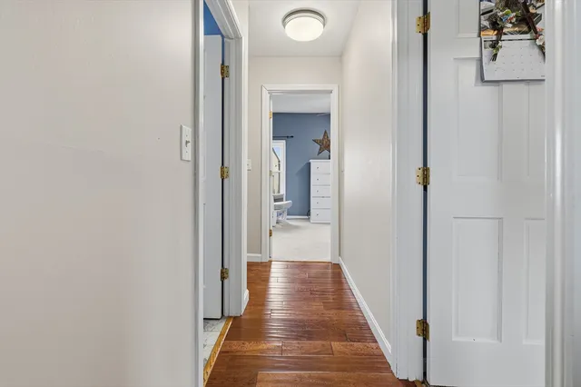 a view of a hallway with wooden floor and closet