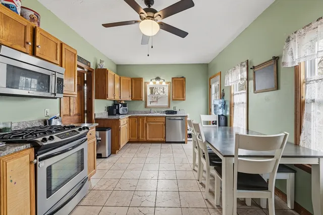 a kitchen with a stove a sink a refrigerator and a dining table