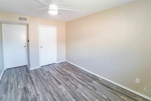 a view of an empty room with wooden floor