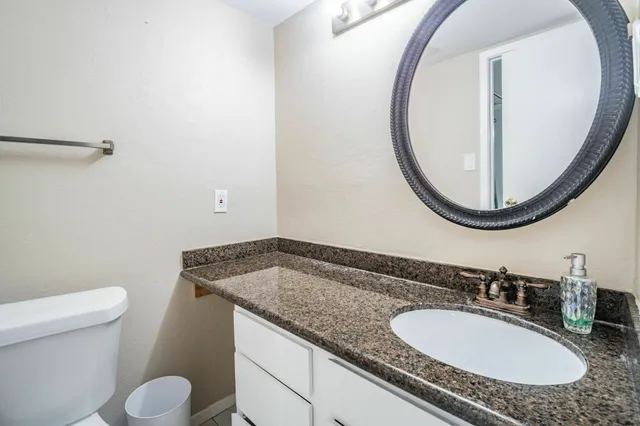 a bathroom with a granite countertop sink and a mirror