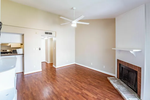 a view of empty room with wooden floor and fireplace