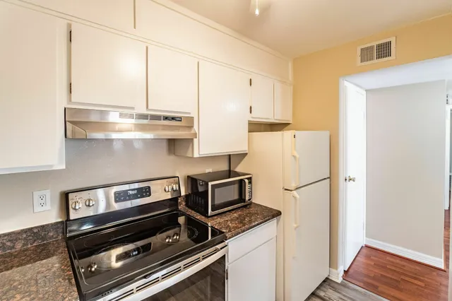 a stove top oven sitting inside of a kitchen
