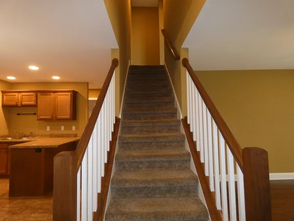 a view of staircase with wooden floor and fan
