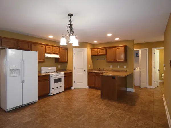 a large kitchen with a refrigerator and a stove top oven