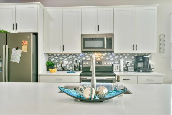 a kitchen with white cabinets and a refrigerator