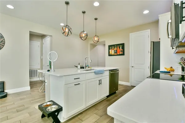 a very nice looking room with kitchen countertop furniture a rug and a chandelier