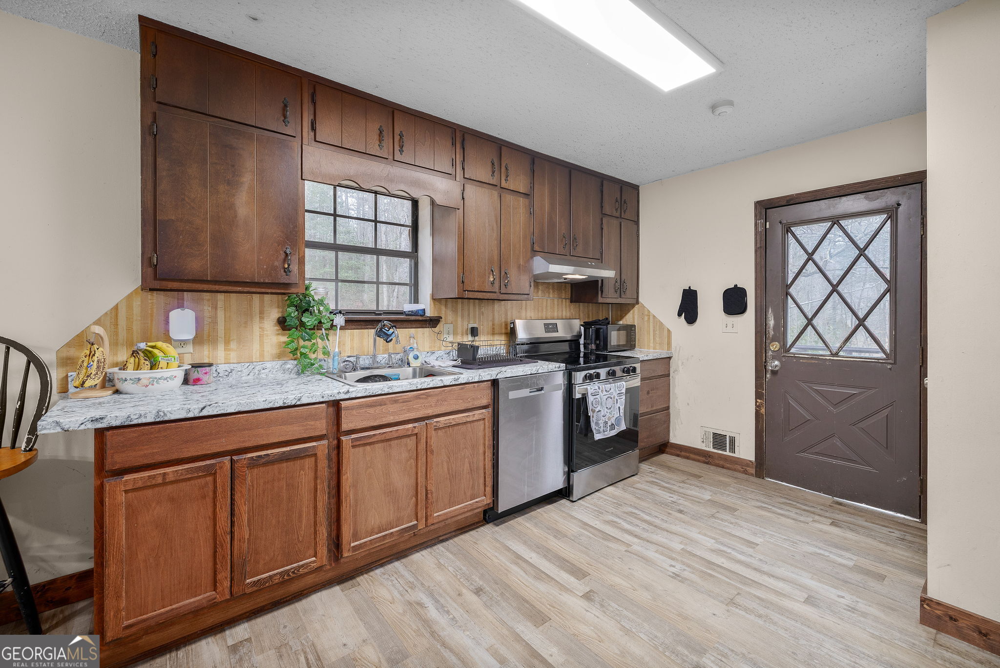 89 Ts Jarrard Road Dahlonega, GA 30533 - Photo 11 of 48 a kitchen with stainless steel appliances granite countertop a sink cabinets and wooden floor