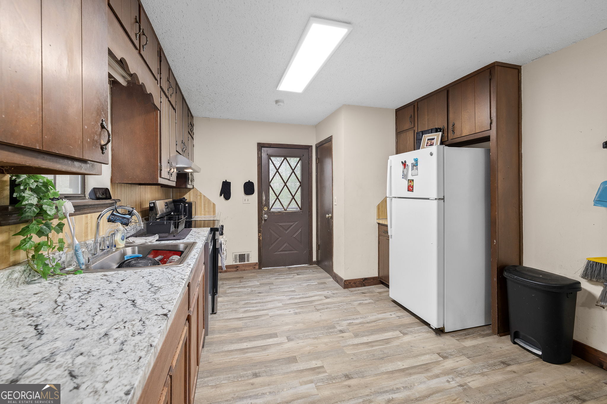 89 Ts Jarrard Road Dahlonega, GA 30533 - Photo 13 of 48 a kitchen with a refrigerator a stove top oven a sink dishwasher and wooden floor