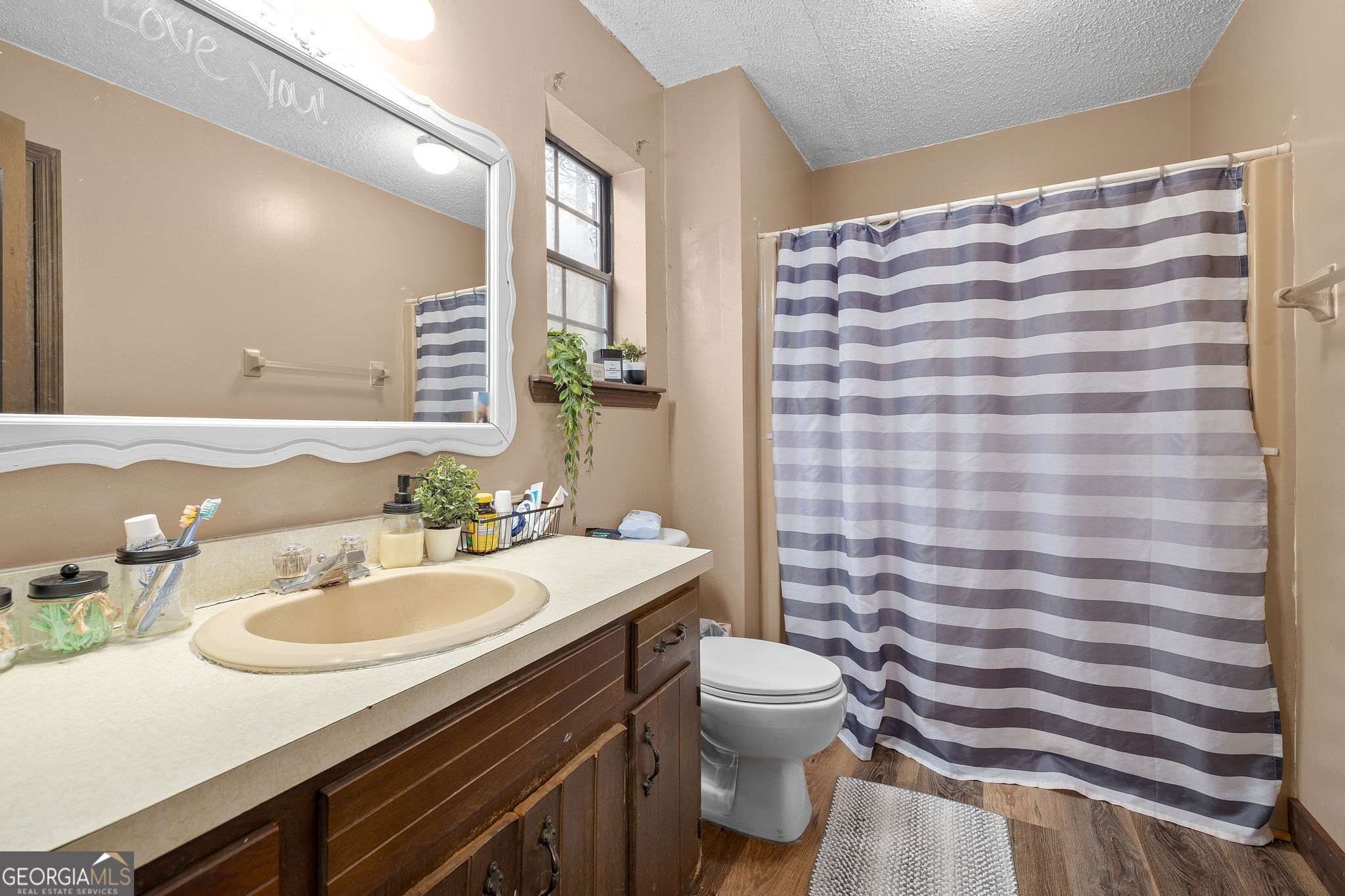 89 Ts Jarrard Road Dahlonega, GA 30533 - Photo 16 of 48 a bathroom with a sink a toilet a mirror and shower curtain