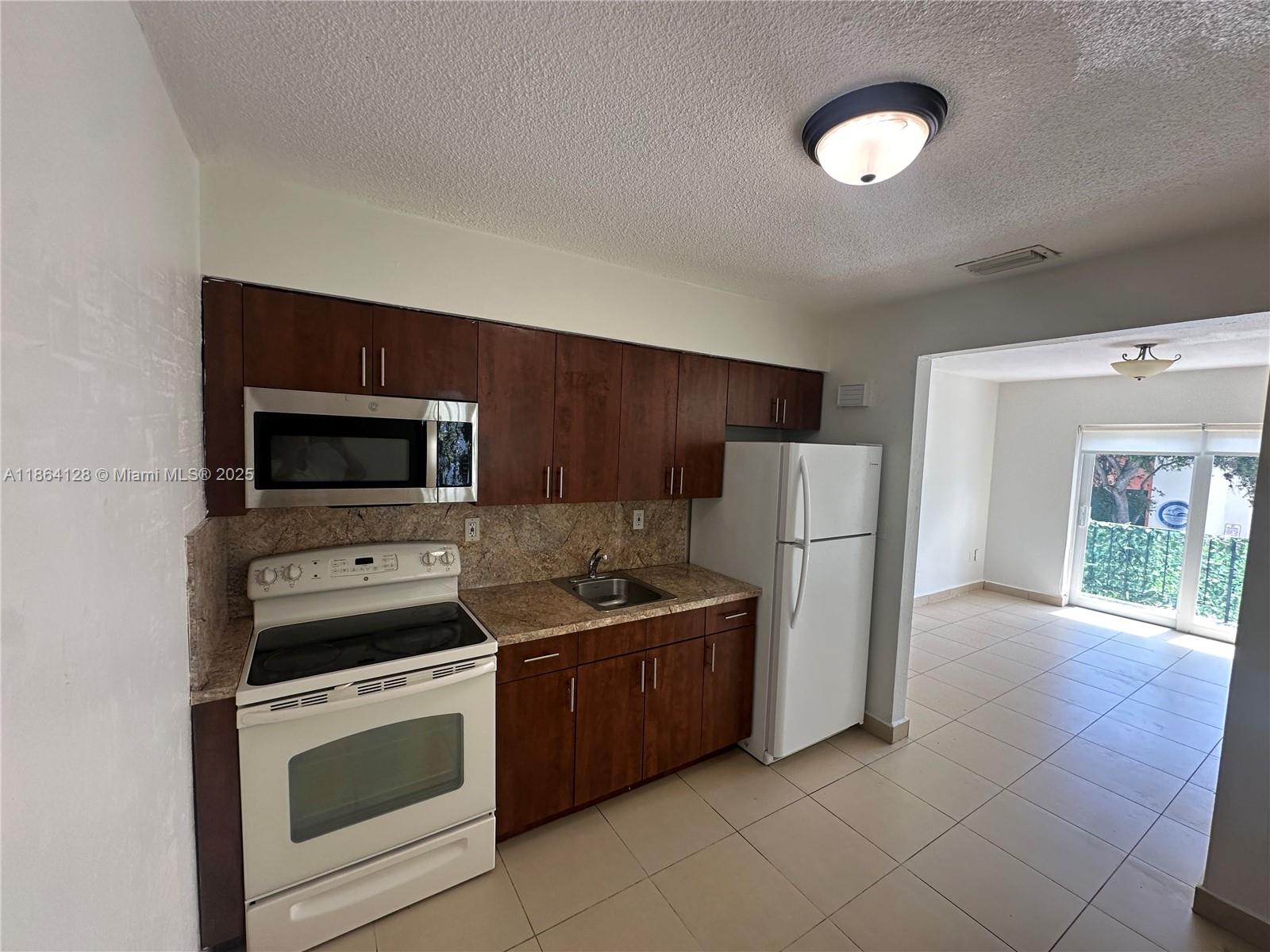 627 Southwest 3rd Street, Unit 4 Miami, FL 33130 - Photo 2 of 12 a kitchen with stainless steel appliances a stove a microwave and a refrigerator