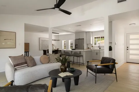 a living room with furniture and a view of kitchen