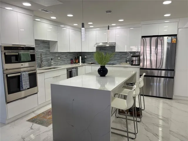 a kitchen with stainless steel appliances kitchen island granite countertop a sink and cabinets