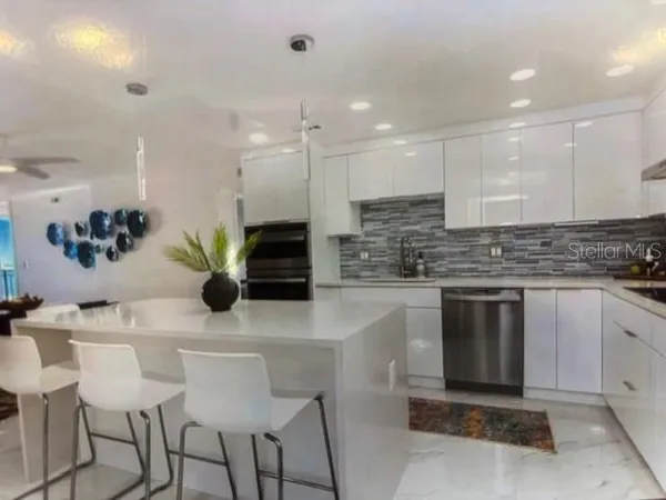 a kitchen with stainless steel appliances kitchen island granite countertop a sink and cabinets