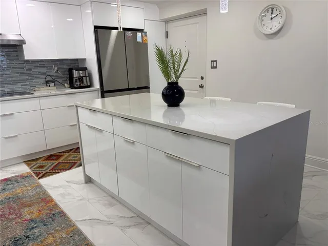 a kitchen with stainless steel appliances granite countertop a refrigerator sink and cabinets