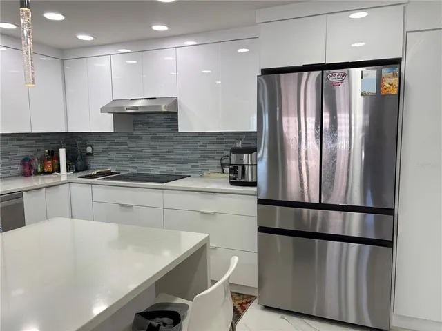 a kitchen with stainless steel appliances granite countertop a sink a stove and a refrigerator