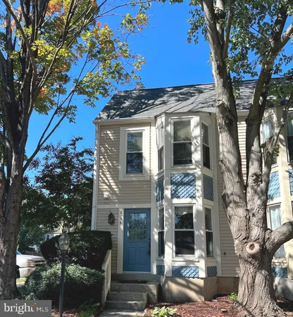 a front view of a house with a tree