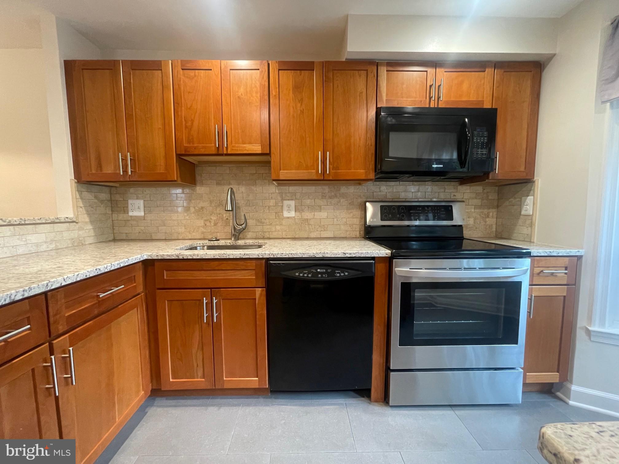 2119 Whisper Way Reston, VA 20191 - Photo 2 of 17 a kitchen with granite countertop a stove top oven microwave and cabinets