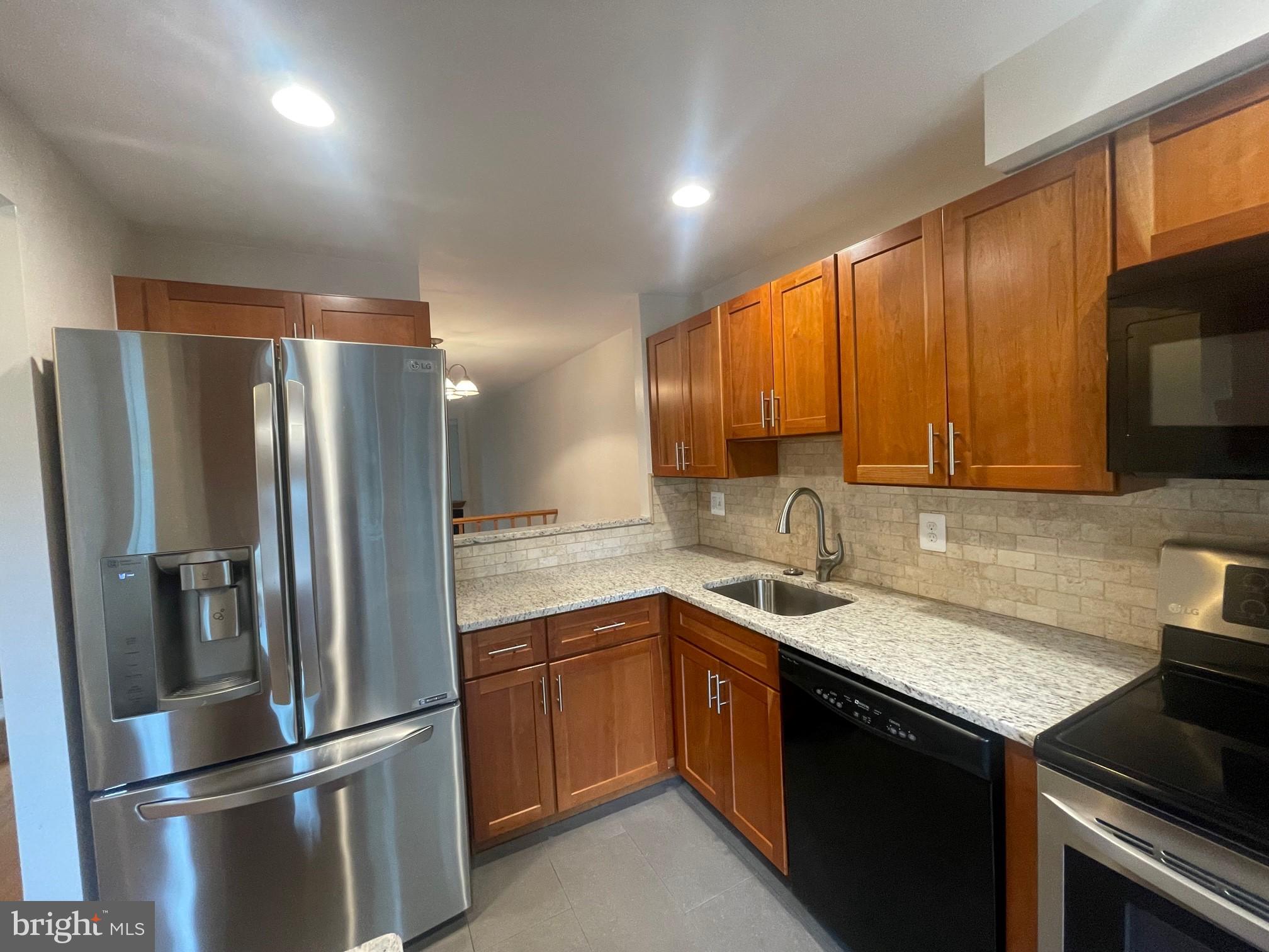 2119 Whisper Way Reston, VA 20191 - Photo 3 of 17 a kitchen with a sink stainless steel appliances and cabinets