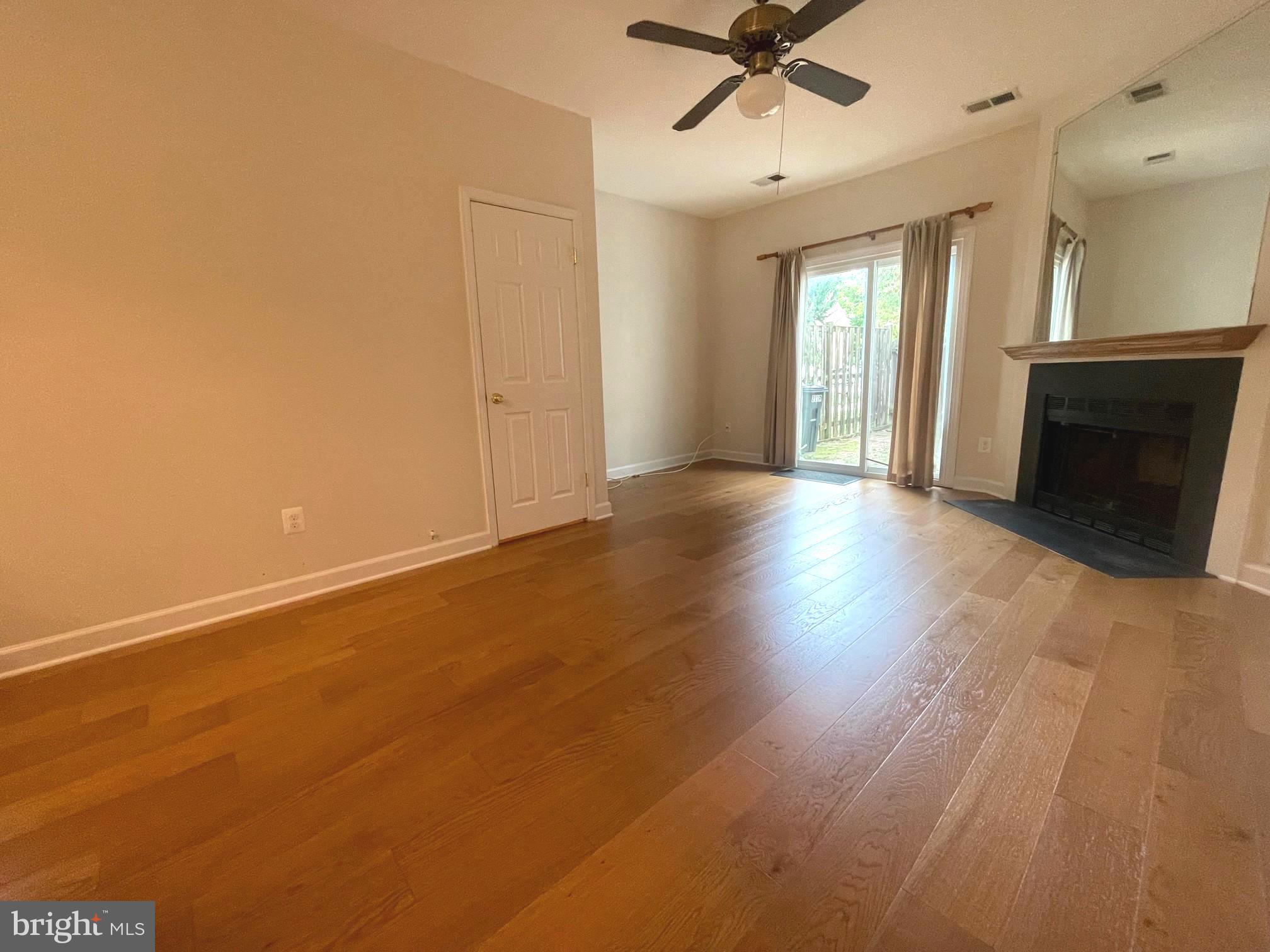 2119 Whisper Way Reston, VA 20191 - Photo 6 of 17 an empty room with wooden floor fireplace and windows