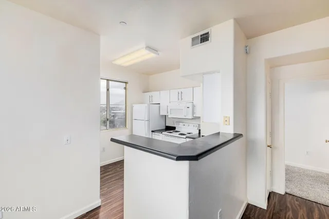 a kitchen with stainless steel appliances granite countertop white cabinets granite counter tops and a wooden floors