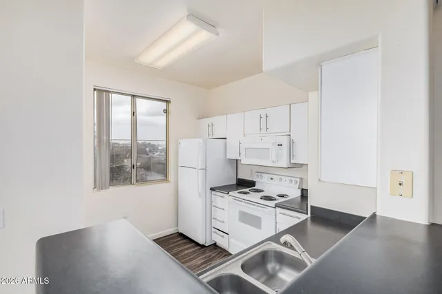 a kitchen with a sink cabinets and wooden floor