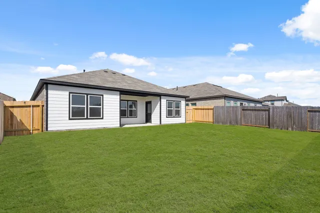 a view of a yard in front of a house with large trees