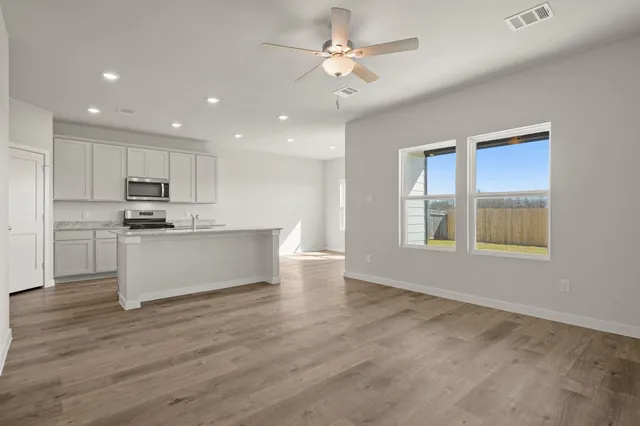 a view of kitchen with granite countertop cabinets and window